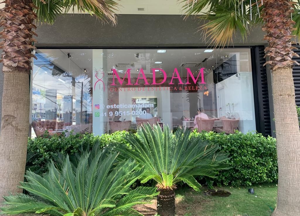 Fachada da MADAM de dia, com jardim de palmeiras